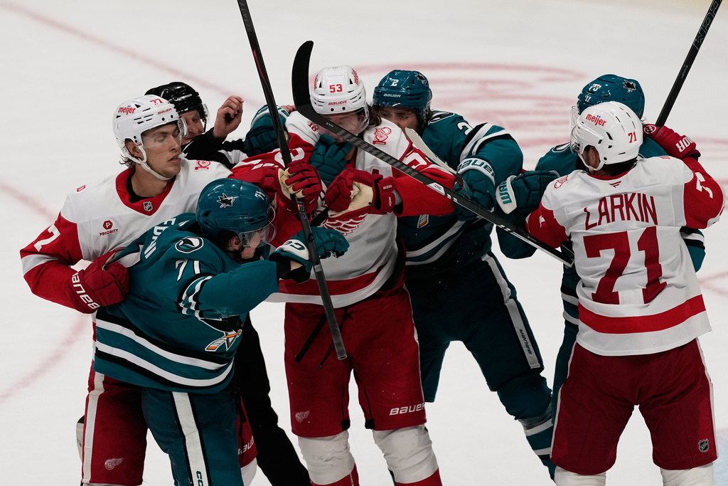A referee tries to separate players from the San Jose Sharks and the Detroit Red Wings during the third period of an NHL hockey game in San Jose, Calif., Sunday, Nov. 2, 2025. (AP Photo/Jeff Chiu)