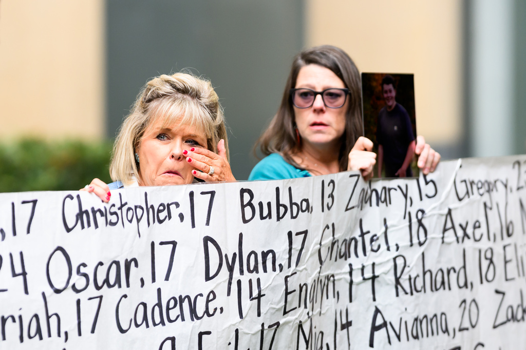 Lori Schott, whose daughter Annalee Schott died at age 18, holds a banner with names of young people who advocates say died as a result of social media outside the Ronald V. Dellums Federal Building and U.S. Courthouse on Tuesday, Aug. 18, 2026, in Oakland, Calif. (AP Photo/Noah Berger)