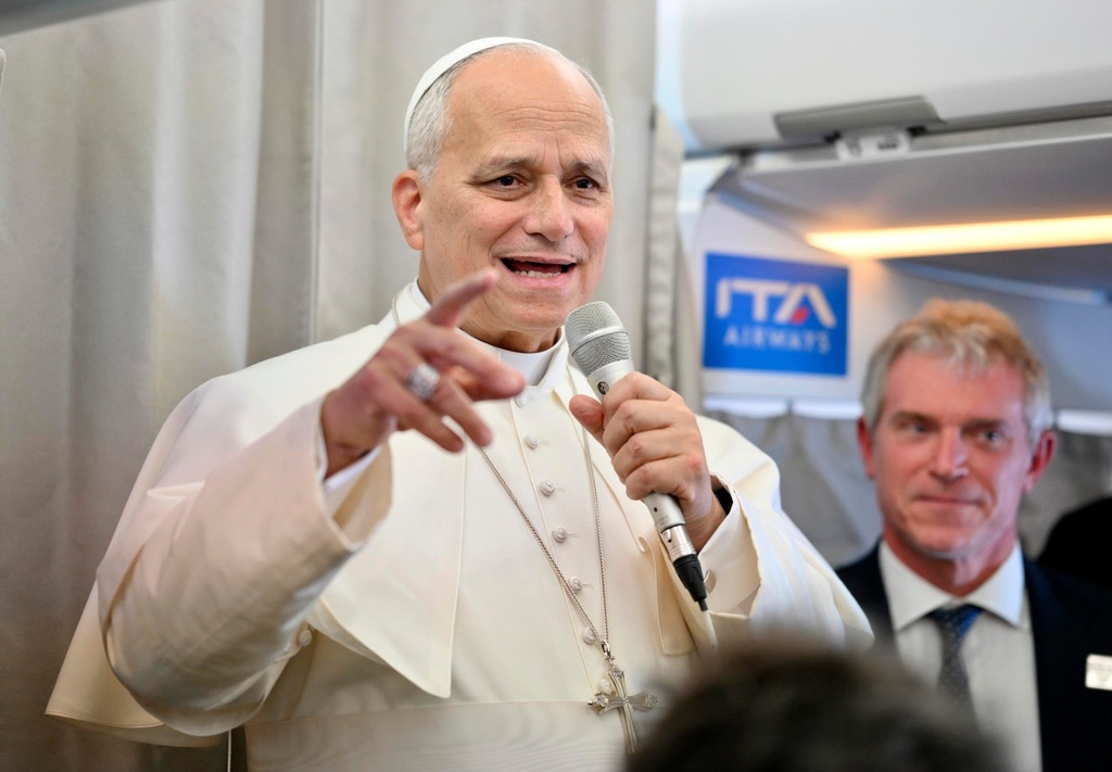 Pope Leo XIV talks to reporters aboard an airplane as he returns from a six-day visit to Turkey and Lebanon, Tuesday, Dec. 2, 2025. (Alessandro Di Meo/Pool Photo via AP)