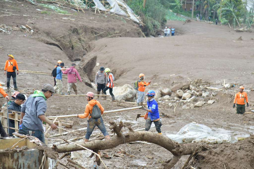 In this photo released by the Indonesian National Search and Rescue Agency (BASARNAS), rescuers search for victims in Pasir Langu village after a landslide, in West Bandung district of West Java province, Indonesia, Sunday, Jan. 25, 2026. (BASARNAS via AP)