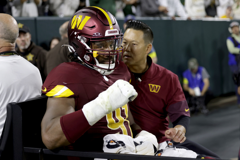 Washington Commanders defensive end Deatrich Wise (91) is taken off on a cart after being injured during the first half of an NFL football game against the Green Bay Packers Thursday, Sept. 11, 2025, in Green Bay, Wis.(AP Photo/Matt Ludtke)
