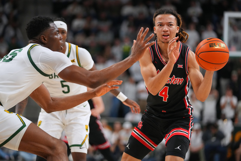 Houston guard Kingston Flemings (4) passes the ball while being pressured by Baylor center James Nnaji, left, during the first half of an NCAA college basketball game Saturday, Jan. 10, 2026, in Waco. (AP Photo/Julio Cortez)