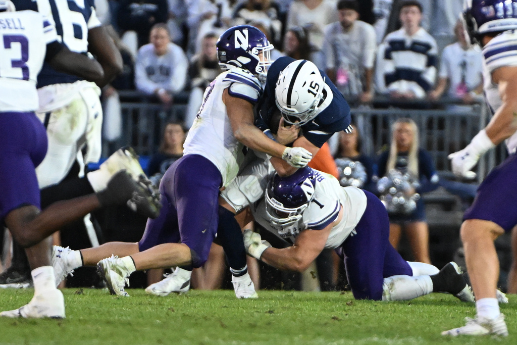 Penn State quarterback Drew Allar (15) is tackled by Northwestern defenders Mac Uihlein (37) and Carmine Bastone (1) during the fourth quarter of an NCAA college football game, Saturday, Oct. 11, 2025, in State College, Pa. (AP Photo/Barry Reeger)