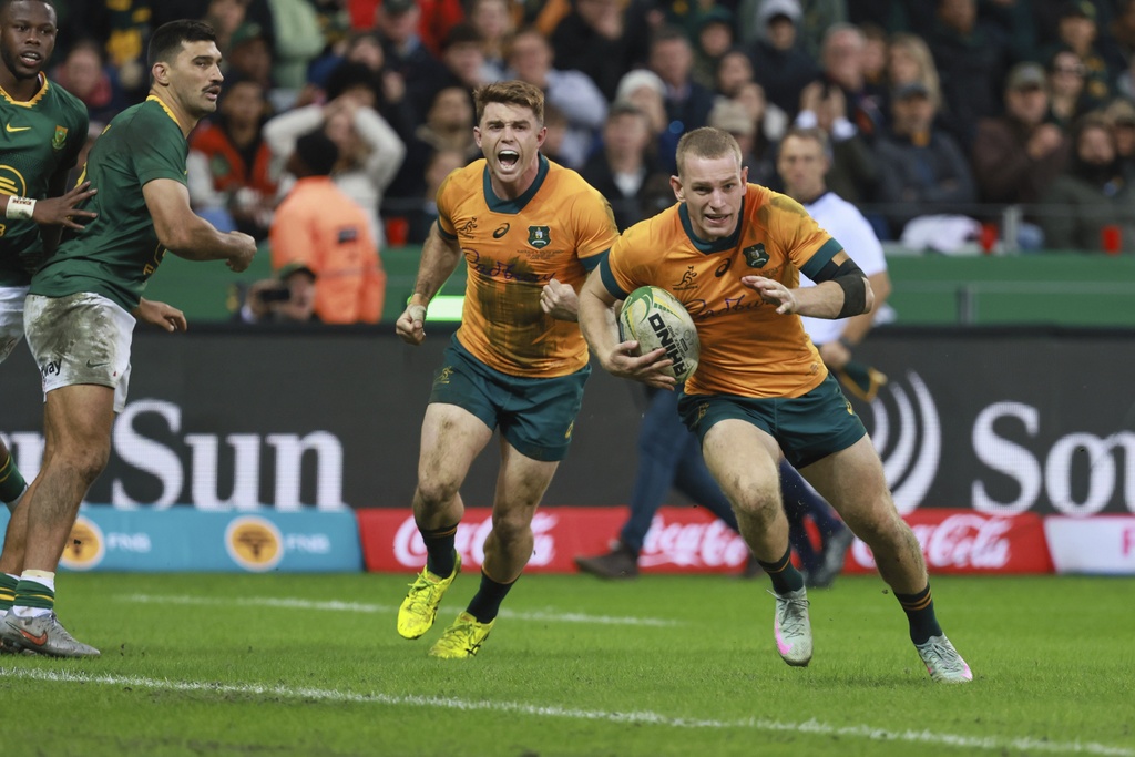 Australia's Max Jorgensen, right, runs to score a try during a rugby championship test match between South Africa and Australia, at Cape Town stadium in Cape Town, South Africa, Saturday, Aug. 23, 2025. (AP Photo/Halden Krog)