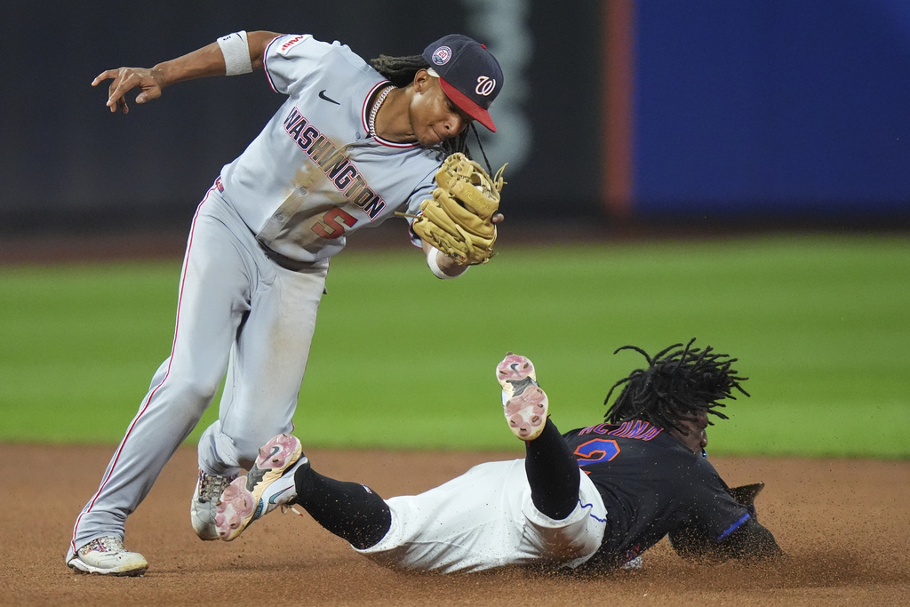 New York Mets' Luisangel Acuña slides past Washington Nationals' CJ Abrams, left, to steal second base during the seventh inning of a baseball game Friday, Sept. 19, 2025, in New York. (AP Photo/Frank Franklin II)