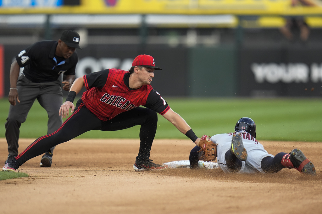 Chicago White Sox shortstop Colson Montgomery, second from left, tags out Cleveland Guardians' Carlos Santana, right, at second base during the third inning of a baseball game Friday, Aug. 8, 2025, in Chicago. (AP Photo/Erin Hooley)