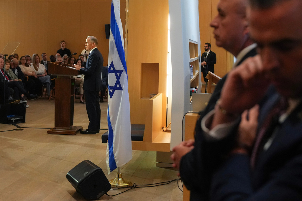 Canadian Prime Minister Mark Carney is flanked by members of his security detail as he delivers remarks at Holy Blossom Temple in Toronto on Monday, June 1, 2026. (Chris Young/The Canadian Press via AP)