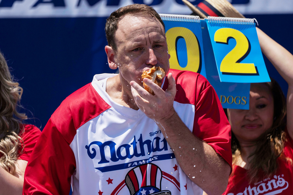 FILE - Joey Chestnut eats hot dogs during the 2025 Nathan's Famous Fourth of July hot dog eating contest in the Coney Island section of the Brooklyn borough of New York, July 4, 2025. (AP Photo/Yuki Iwamura, File)