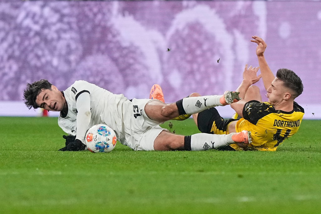 Moenchengladbach's Giovanni Reyna, left, and Dortmund's Nico Schlotterbeck challenge for the ball during the German Bundesliga soccer match between Borussia Dortmund and Borussia Moenchengladbach in Dortmund, Germany, Friday, Dec. 19, 2025. (AP Photo/Martin Meissner)