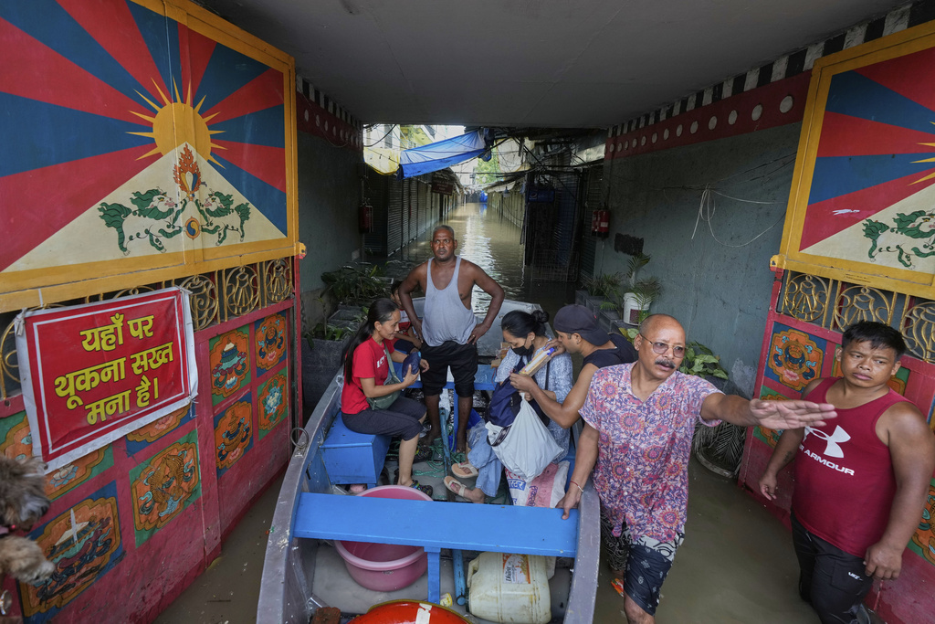 Residents of a Tibetan refugee colony use boat after the Yamuna river, swollen by incessant rain in the higher regions, overran its banks in New Delhi, India, Friday, Sept. 5, 2025. (AP Photo/Manish Swarup)