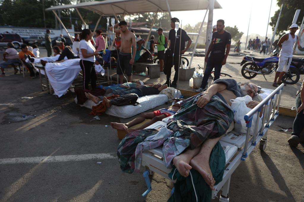 Patients lie outside a hospital evacuated after it was damaged in an earthquake in Catia La Mar, Venezuela, Thursday, June 25, 2026. (AP Photo/Pedro Mattey)