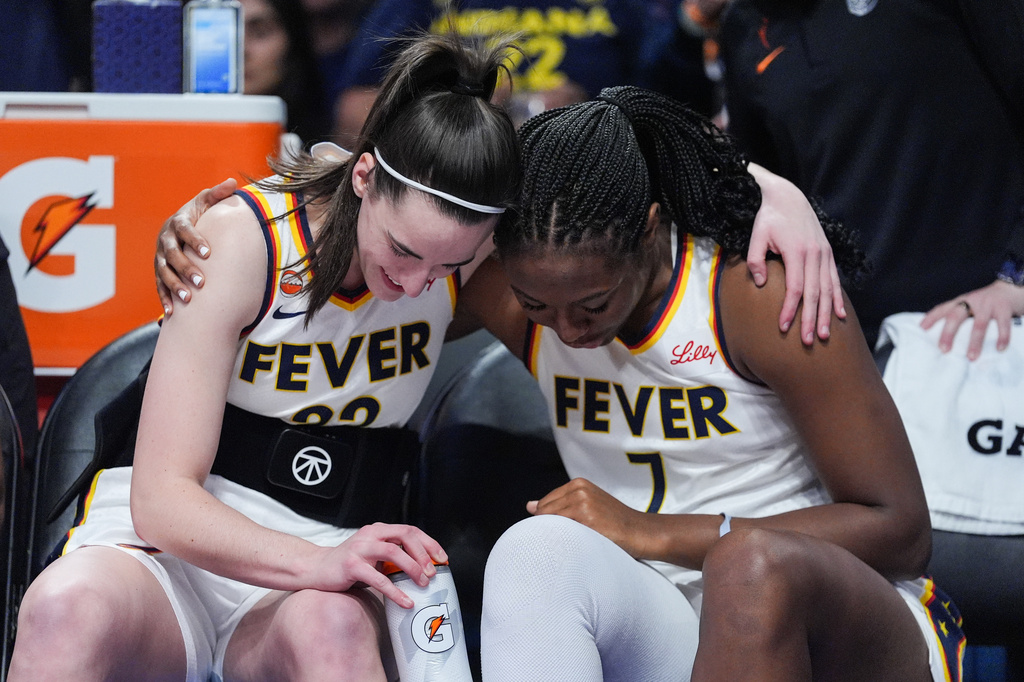 Indiana Fever guard Caitlin Clark (22) and center-forward Aliyah Boston (7) share a moment before the first half of a WNBA basketball game against the Los Angeles Sparks Wednesday, May 13, 2026, in Los Angeles. (AP Photo/Jae C. Hong)