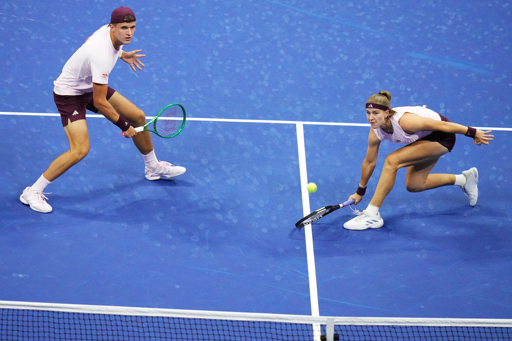Jakub Mensik, left, of the Czech Republic, watches as Karolina Muchova, also of the Czech Republic, returns the ball against Mirra Andreeva, of Russia, and Andrey Rublev, also of Russia, during a mixed doubles semifinal match at the U.S. Open tennis championships Wednesday, Aug. 26, 2026, in New York. (AP Photo/Frank Franklin II)