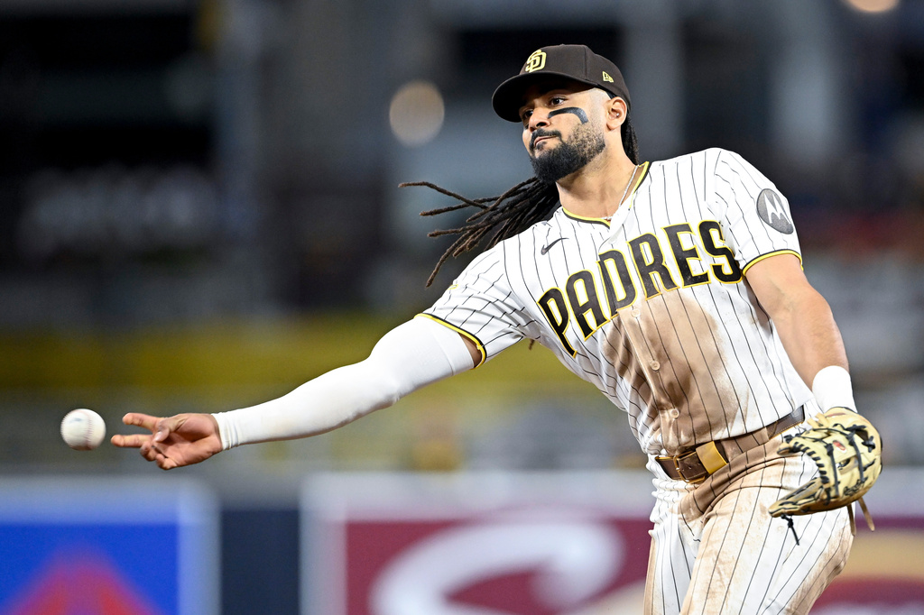 San Diego Padres second baseman Fernando Tatis Jr. (23) throws out Colorado Rockies' Troy Johnston (20) at first base during the sixth inning of a baseball game Saturday, April 11, 2026, in San Diego. (AP Photo/Denis Poroy)