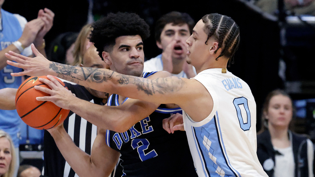 Duke guard Cayden Boozer (2) looks to pass the ball as North Carolina guard Kyan Evans (0) defends during the first half of an NCAA college basketball game Saturday, Feb. 7, 2026, in Chapel Hill, N.C. (AP Photo/Chris Seward)