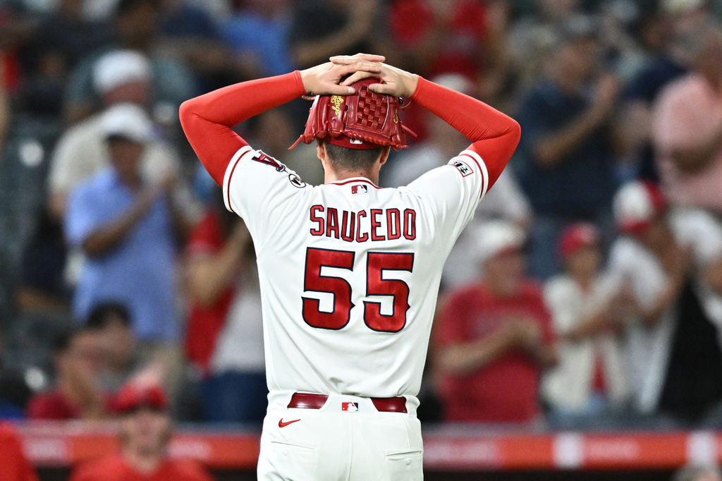 Los Angeles Angels pitcher Tayler Saucedo reacts while walking back to the dugout after a catch by right fielder Wade Meckler during the seventh inning of a baseball game against the Texas Rangers, Monday, Aug. 10, 2026, in Anaheim, Calif. (AP Photo/William Liang)