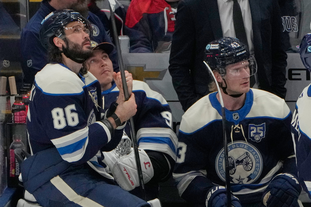 Columbus Blue Jackets right wing Kirill Marchenko (86), goaltender Elvis Merzlikins, center, and left wing Danton Heinen (43) watch the scoreboard as officials determine a shot bty Marchenko was a goal in the second period of an NHL game against the Carolina Hurricanes in Columbus, Tuesday, March 31, 2026. (AP Photo/Sue Ogrocki)