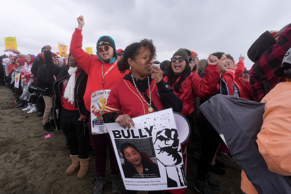 Tylynn Lewis, teacher at Dr. Charles R. Drew Elementary School, middle, rallies in support of the ongoing teacher's strike at the San Francisco Unified School District with other teachers, students and supporters at Ocean Beach, in San Francisco, Wednesday, Feb. 11, 2026. (AP Photo/Jeff Chiu)