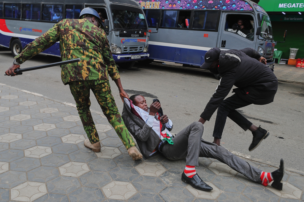 Police officers arrests a protester near the Parliament, during a demonstration marking two years since the 2024 anti-government protests, in Nairobi, Kenya, Thursday, June 25, 2026. (AP Photo/Henry Naminde)