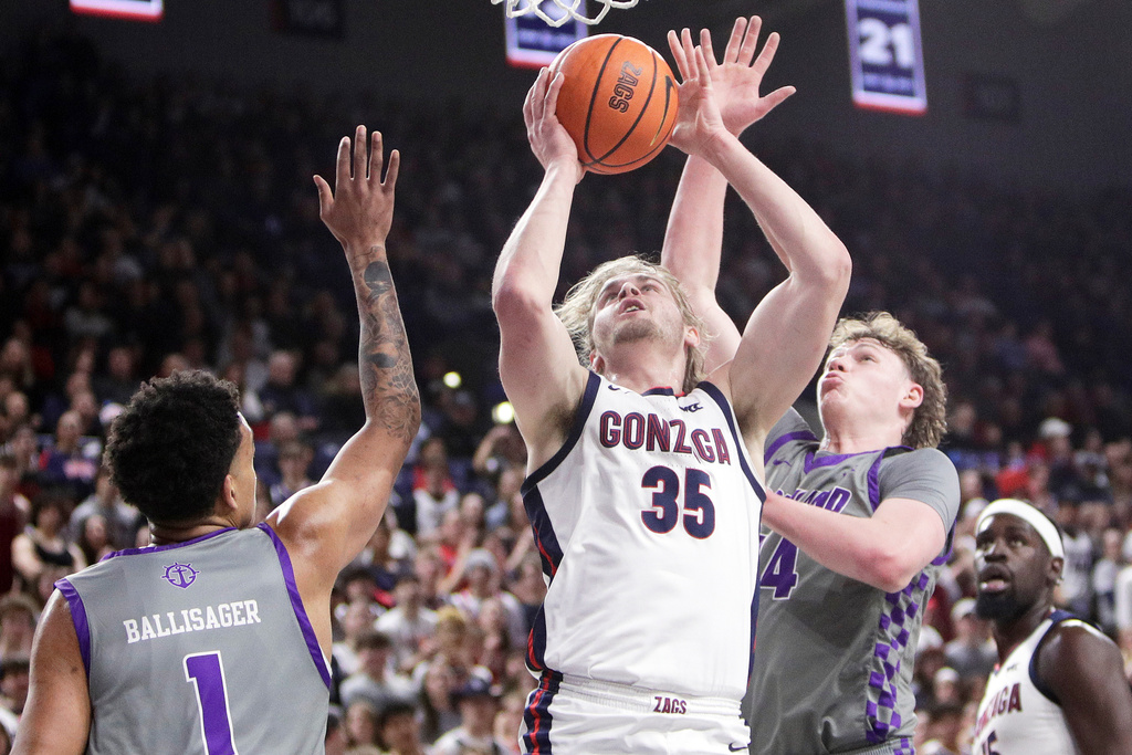 Gonzaga forward Noah Haaland (35) shoots between Portland center Jermaine Ballisager Webb (1) and forward James O'Donnell, left, during the first half of an NCAA college basketball game, Wednesday, Feb. 25, 2026, in Spokane, Wash. (AP Photo/Young Kwak)