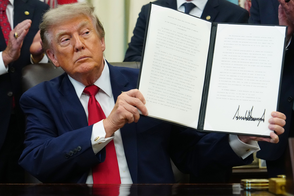 President Donald Trump holds a signed executive order modifying the Bears Ears National Monument in the Oval Office of the White House, Monday, July 13, 2026, in Washington. (AP Photo/Julia Demaree Nikhinson)