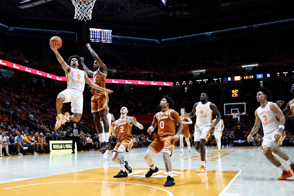 Tennessee guard Ja'kobi Gillespie (0) shoots past Texas guard Tramon Mark (12) during the first half of an NCAA college basketball game Tuesday, Jan. 6, 2026, in Knoxville, Tenn. (AP Photo/Wade Payne)