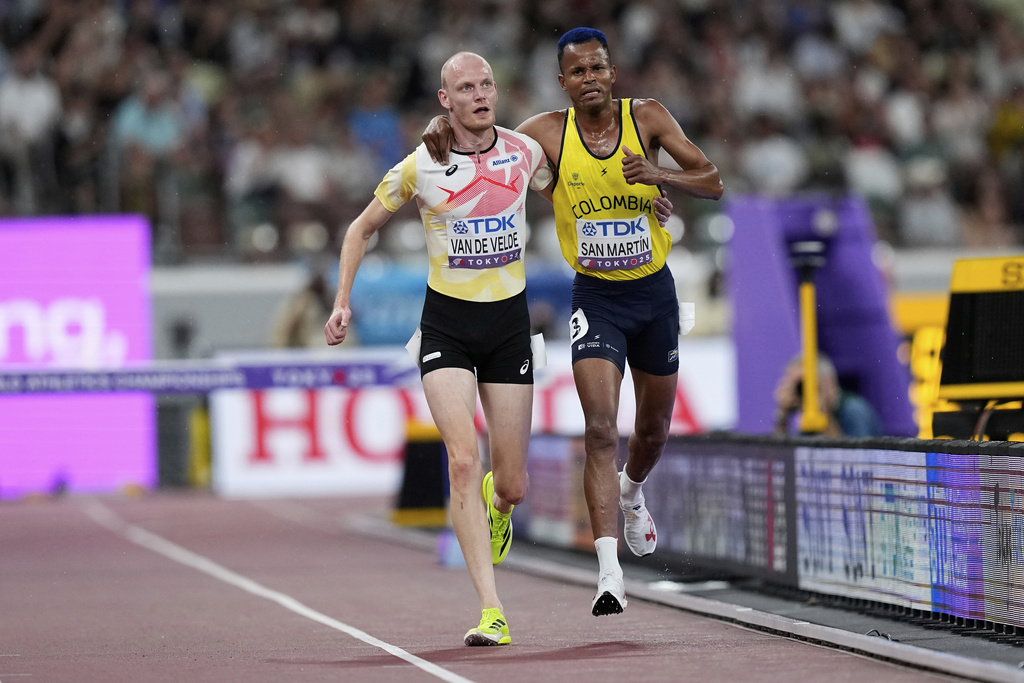 Colombia's Carlos San Martin and Belgium's Tim Van De Velde help each other to the nine during a men's 3,000 meters steeplechase heat at the World Athletics Championships in Tokyo, Saturday, Sept. 13, 2025. (AP Photo/Petr David Josek)