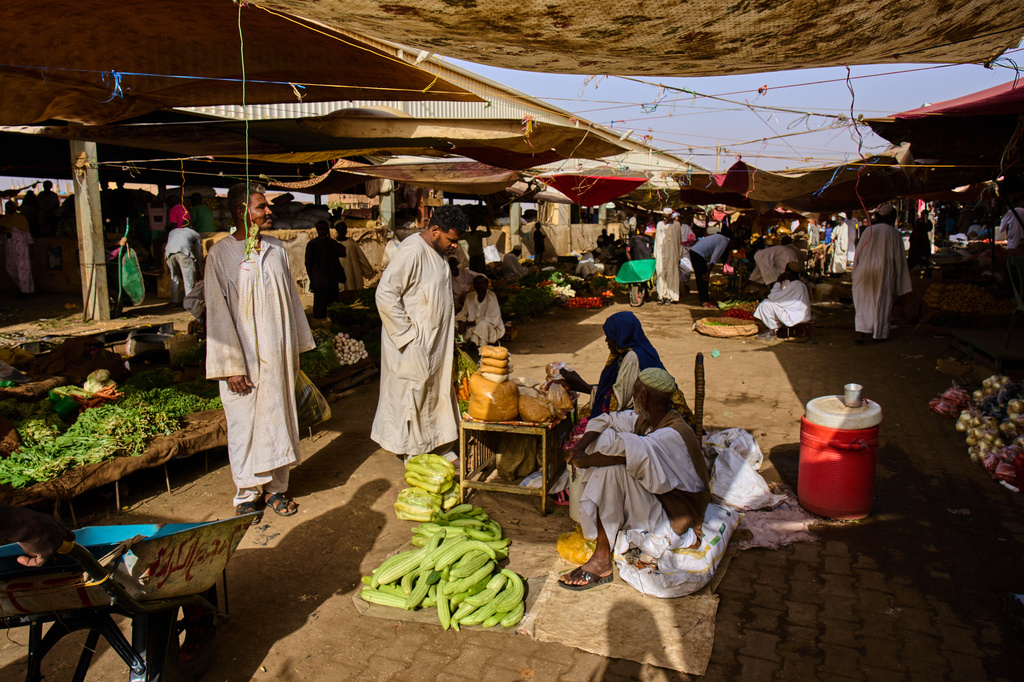 Customers buy vegetables at a market in Omdurman, on the outskirts of Khartoum, Sudan, Sunday, April 26, 2026. (AP Photo/Bernat Armangue)