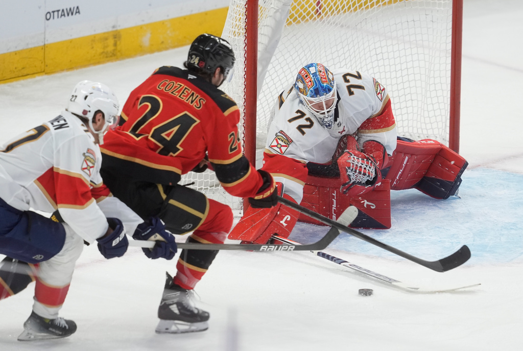 Florida Panthers goaltender Sergei Bobrovsky (72) pokes the puck away from Ottawa Senators' Dylan Cozens (24) during first-period NHL hockey game action in Ottawa, Ontario, Thursday, April 9, 2026. (Adrian Wyld/The Canadian Press via AP)