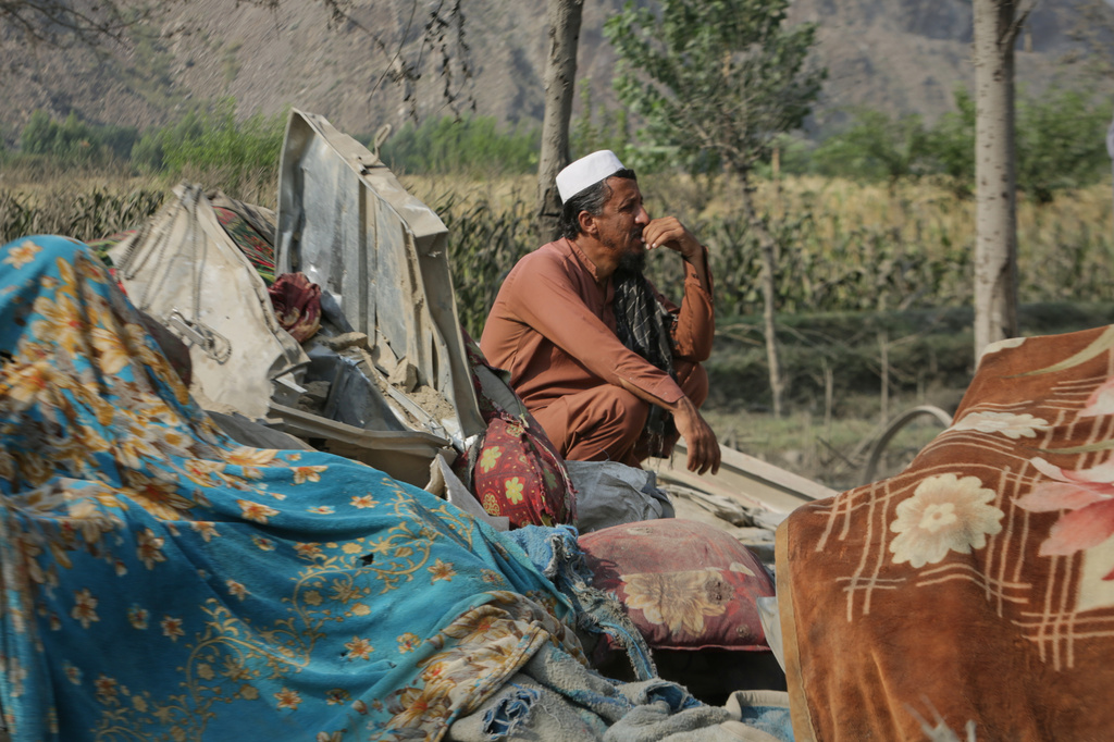A man sits amid household belongings and the wreckage of a house destroyed in a strike in Patan village, Kunar province, eastern Afghanistan, Monday, Sept. 21, 2026. (AP Photo/Shafiullah Kakar)