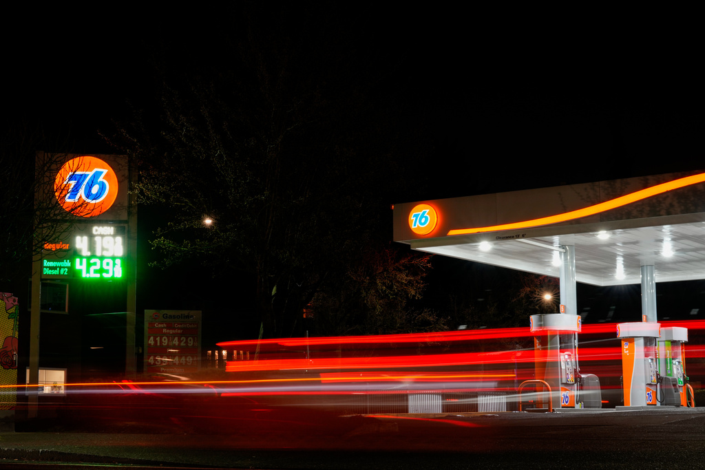 FILE - Vehicles drive past a gas station as gasoline prices are displayed March 4, 2026, in Portland, Ore. (AP Photo/Jenny Kane, File)