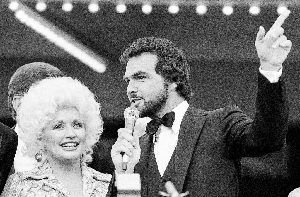 FILE - Dolly Parton, left, and Burt Reynolds appear at the premier of their film "The Best little Whorehouse in Texas" in Austin, on July 12, 1982. (AP Photo/Ted Powers, File)