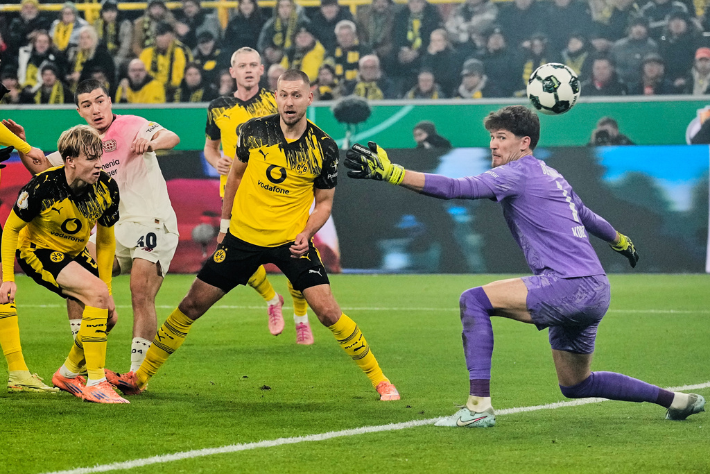 Leverkusen's Ibrahim Maza, second from left, scores the opening goal during the German Soccer Cup round of sixteen soccer match between Borussia Dortmund and Bayer 04 Leverkusen in Dortmund, Germany, Tuesday, Dec. 2, 2025. (AP Photo/Martin Meissner)