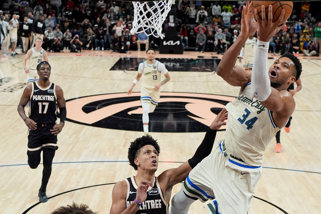 Milwaukee Bucks forward Giannis Antetokounmpo (34) shoots against Atlanta Hawks forward Jalen Johnson (1) during the second half of an NBA basketball game, Monday, Jan. 19, 2026, in Atlanta. (AP Photo/Mike Stewart)