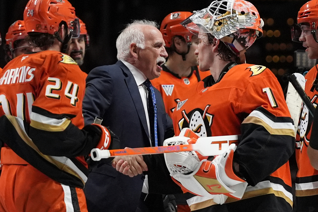 Anaheim Ducks head coach Joel Quenneville, center, celebrates with goaltender Lukas Dostal (1) after winning his 1,000th career coaching victory with a 6-4 win over the Edmonton Oilers in an NHL hockey game Wednesday, Feb. 25, 2026, in Anaheim, Calif. (AP Photo/Gregory Bull)