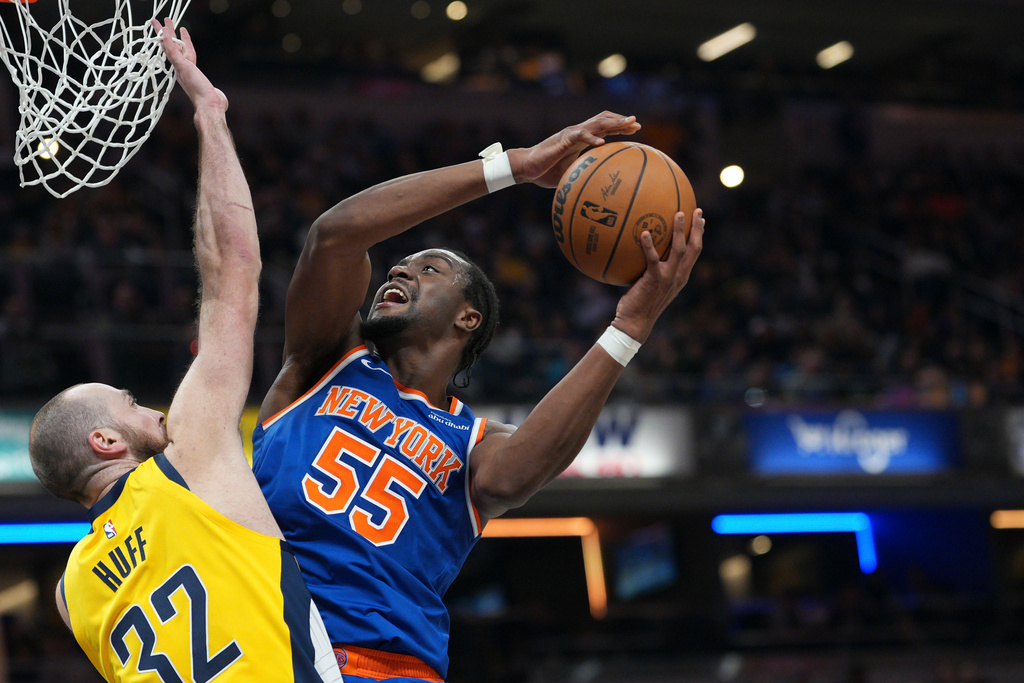 New York Knicks center Ariel Hukporti (55) shoots over Indiana Pacers center Jay Huff (32) during the first half of an NBA basketball game in Indianapolis, Thursday, Dec. 18, 2025. (AP Photo/AJ Mast)