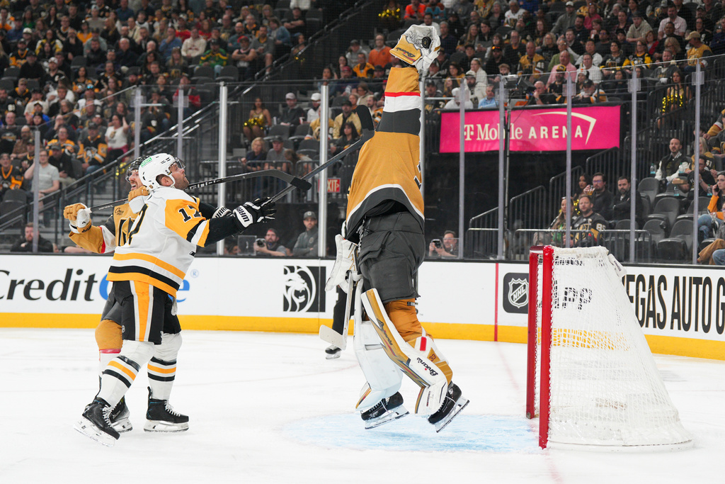 Vegas Golden Knights goaltender Adin Hill (33) stops a shot against Pittsburgh Penguins right wing Bryan Rust (17) during the first period of an NHL hockey game Thursday, March 12, 2026, in Las Vegas. (AP Photo/Candice Ward)