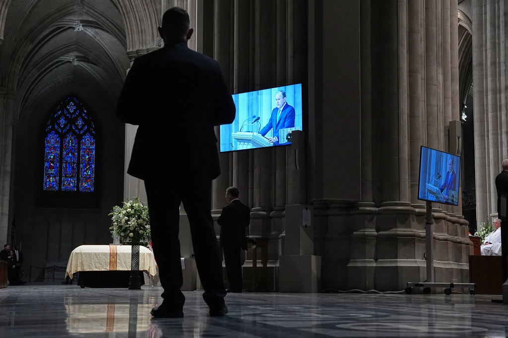 Former President George W. Bush is seen speaking a tribute on the monitors during the funeral for former Vice President Dick Cheney at the Washington National Cathedral, Thursday, Nov. 20, 2025 in Washington. (AP Photo/Matt Rourke)