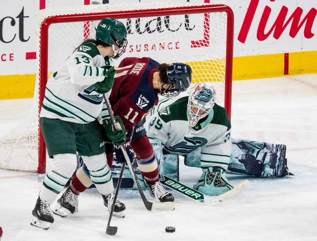 Boston Fleet goaltender Abbey Levy (39) makes a save against Montreal Victoire's Abby Roque (11) while Fleet's Liz Schepers (13) stands in front of the net during third-period PWHL hockey game action in Laval, Quebec, Friday, April 17, 2026. (Christopher Katsarov/The Canadian Press via AP)