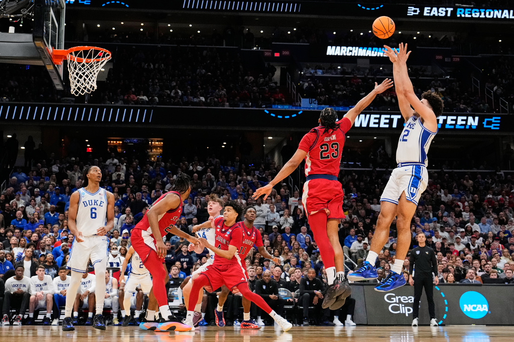 Duke forward Cameron Boozer (12) shoots over St. John's forward Bryce Hopkins (23) during the second half in the Sweet 16 of the NCAA college basketball tournament, Friday, March 27, 2026, in Washington. (AP Photo/Abbie Parr)