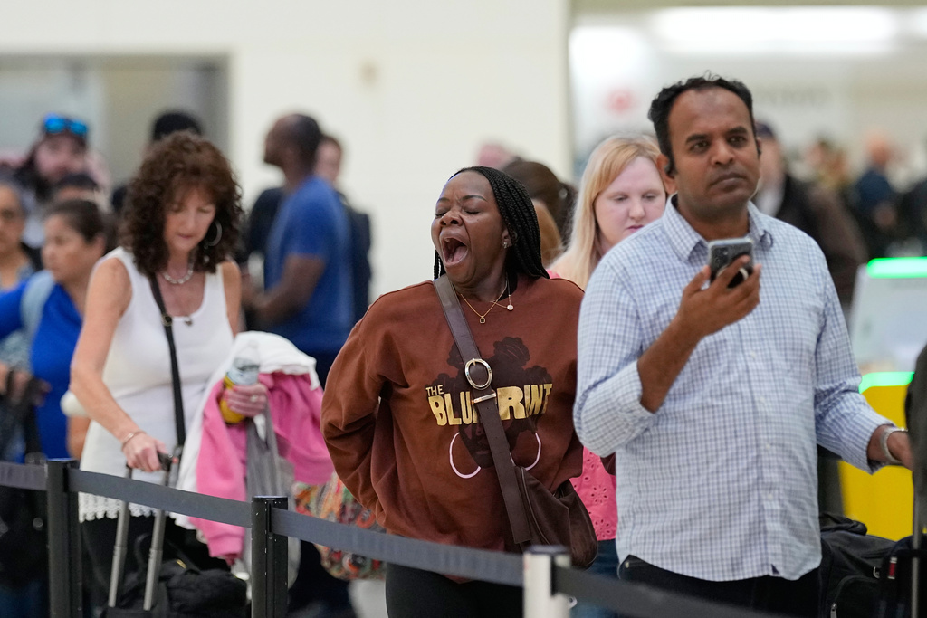 Passengers wait in a security checkpoint line at George Bush Intercontinental Airport, Wednesday, March 25, 2026, in Houston. (AP Photo/David J. Phillip)
