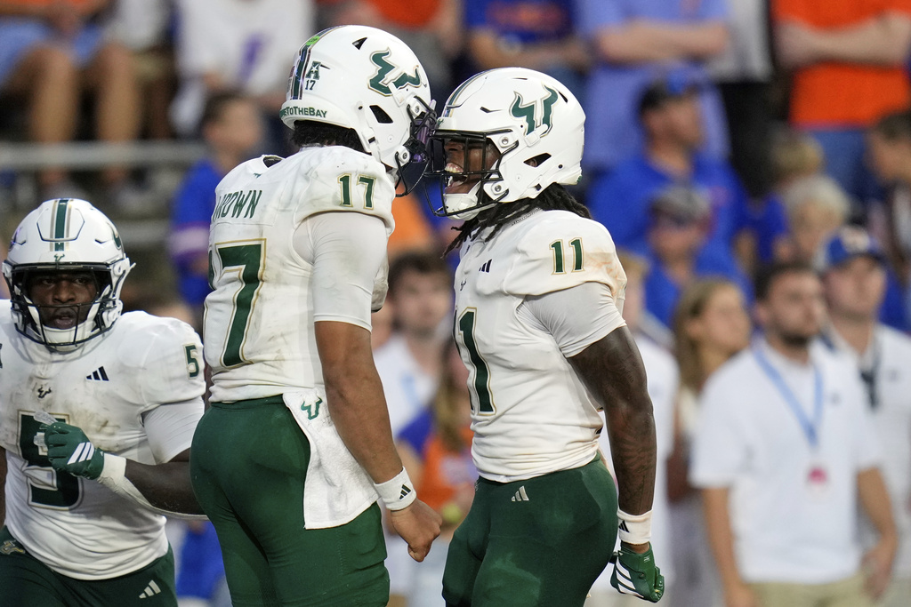South Florida wide receiver Keshaun Singleton (11) celebrates his 66-yard touchdown against Florida with quarterback Byrum Brown (17) during the second half of an NCAA college football game, Saturday, Sept. 6, 2025, in Gainesville, Fla. (AP Photo/John Raoux)