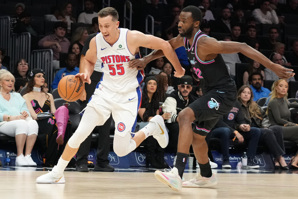 Detroit Pistons forward Duncan Robinson (55) dribbles the ball as Miami Heat forward Andrew Wiggins (22) defends during the first half of an NBA basketball game Saturday, Nov. 29, 2025, in Miami. (AP Photo/Marta Lavandier)