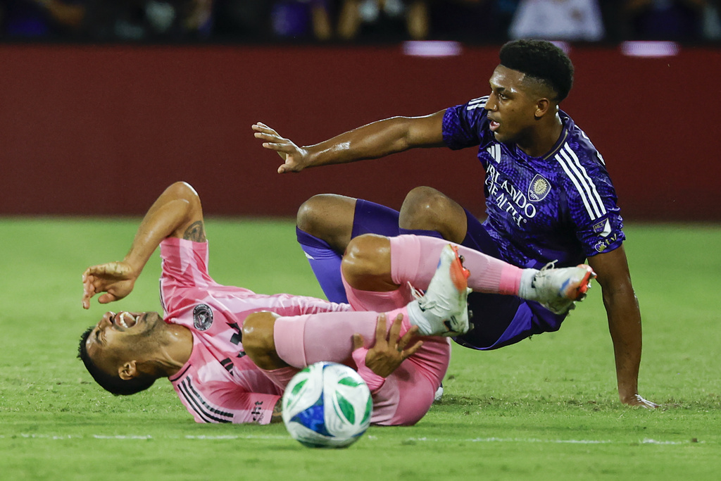Orlando City defender Alex Freeman, right, slides into Inter Miami forward Luis Suárez, left, during the first half of an MLS soccer match, Sunday, Aug. 10, 2025, in Orlando, Fla. (AP Photo/Kevin Kolczynski)