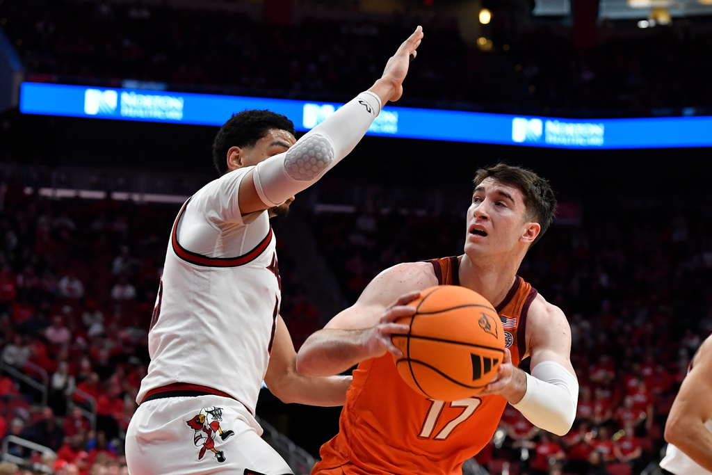Virginia Tech guard Neoklis Avdalas (17) looks to pass away from Louisville forward Sananda Fru (13) during the first half of an NCAA college basketball game in Louisville, Ky., Saturday, Jan. 24, 2026. (AP Photo/Timothy D. Easley)