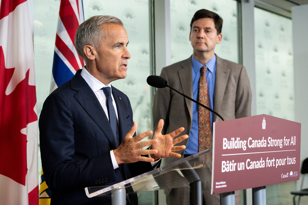 Prime Minister Mark Carney speaks accompanied by British Columbia Premier David Eby, right, in Vancouver, on Thursday, July 2, 2026. (Ethan Cairns/The Canadian Press via AP)
