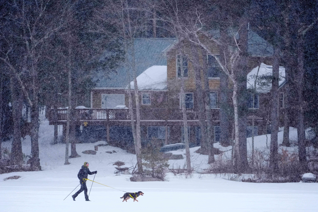 Cross country skier Nate Andrew is pulled by his dog, Frankie, while traversing Moose Pond during a snowstorm, Wednesday, Feb. 25, 2026, in Bridgton, Maine. (AP Photo/Robert F. Bukaty)