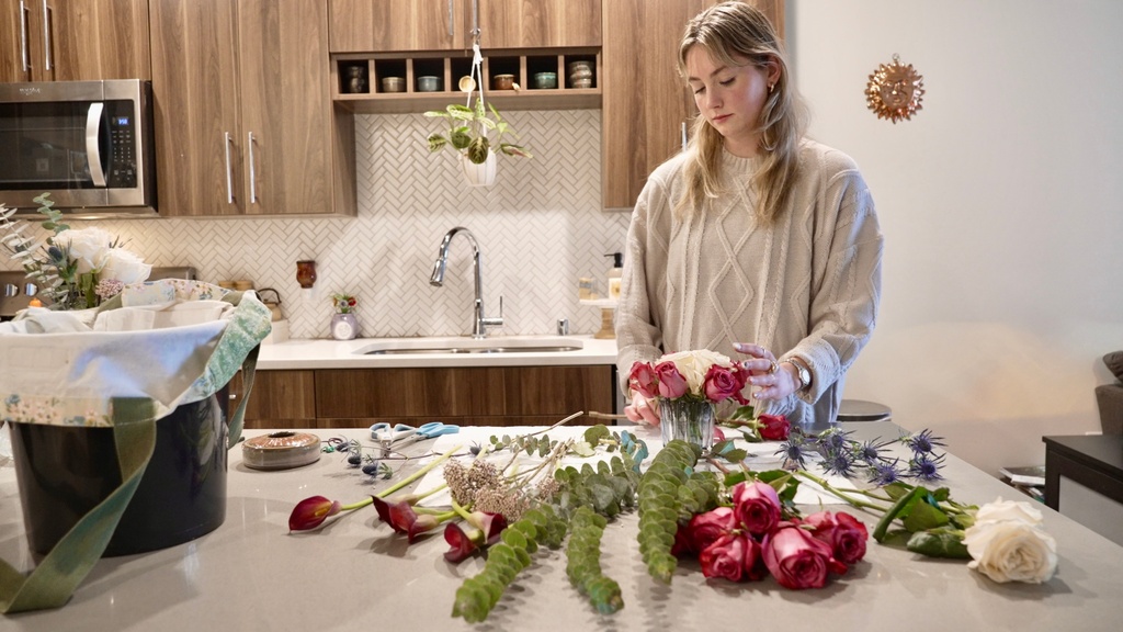 Megan Feller arranges bouquets for a Halloween party at her apartment in Edina, Minn. on Saturday, Oct. 25, 2025. (AP Photo/Mark Vancleave)