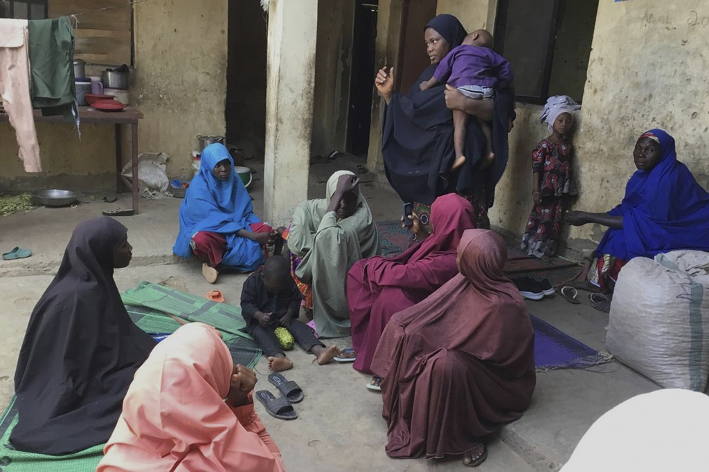Amina Hassan, standing, wife of the vice principal of the Government Girls Comprehensive Secondary School, where gunmen on Monday attacked the school dormitory, abducted schoolgirls and killed her husband, with mourners, in Kebbi, Nigeria, Tuesday, Nov. 18, 2025. (AP Photo/Tunde Omolehin)