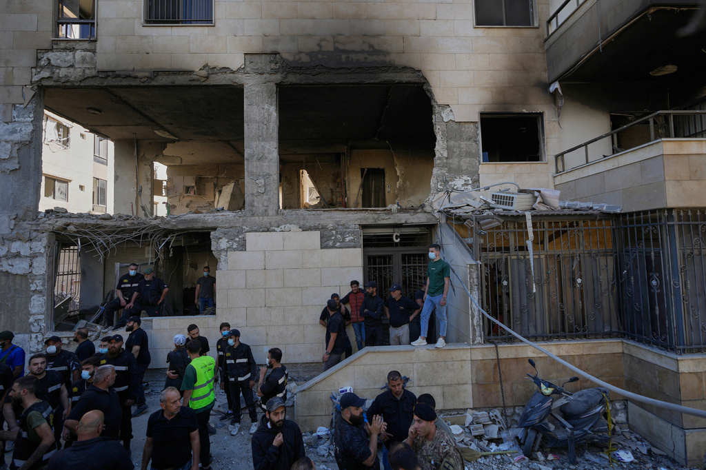 People and security officers gather in front of a destroyed apartment that was hit in an Israeli airstrike in the town of Choueifat, south of Beirut, Lebanon, Thursday, May 28, 2026. (AP Photo/Hussein Malla)